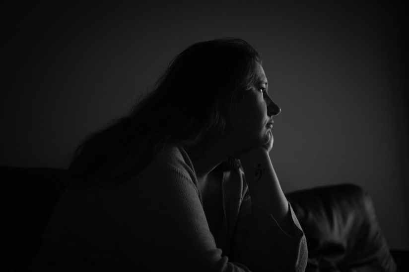 grayscale photography of woman sitting on sofa